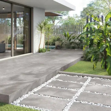 Terraza moderna con piso de loseta gris y jardín decorativo, entrada a casa minimalista