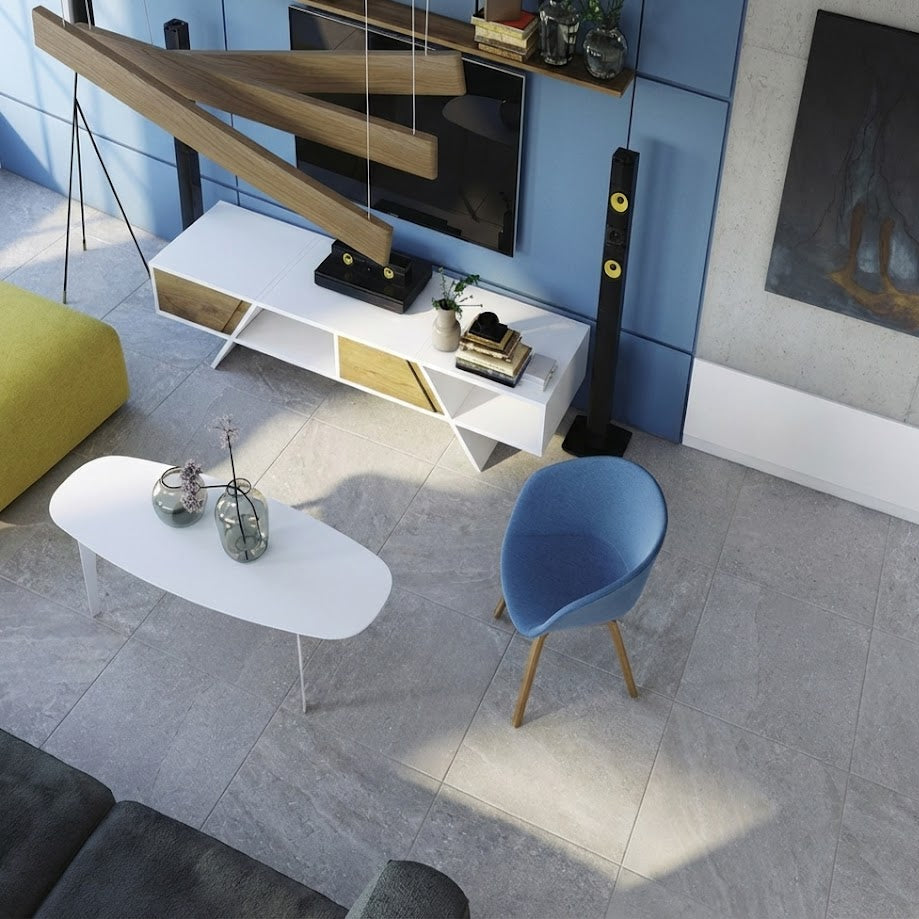 Sala moderna con piso cerámico gris, mesa blanca, silla azul y mueble bajo de TV.